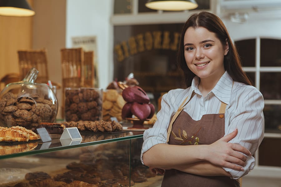 Charming Young Female Baker Smiling To The Camera, Posing Proudl